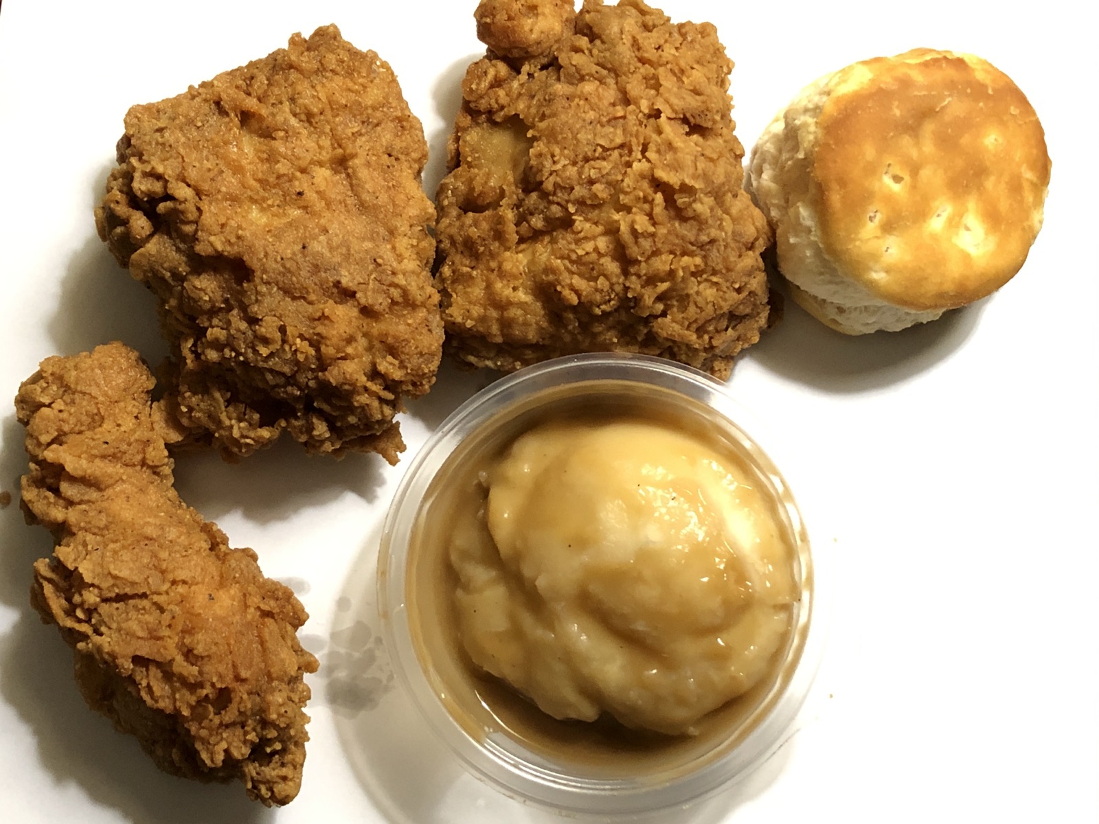 KFC chicken pieces with a biscuit and side dish